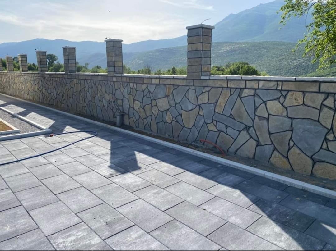 Terrassenpflaster mit Natursteinmauer